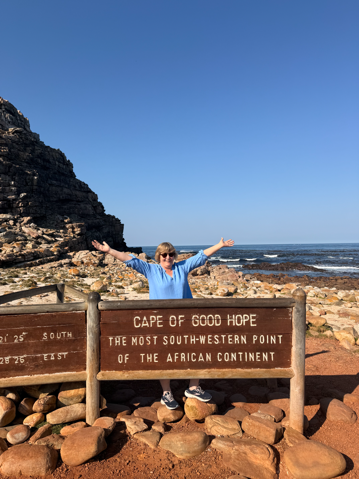 Helen Mc Crarren standing with her arms open at the coast