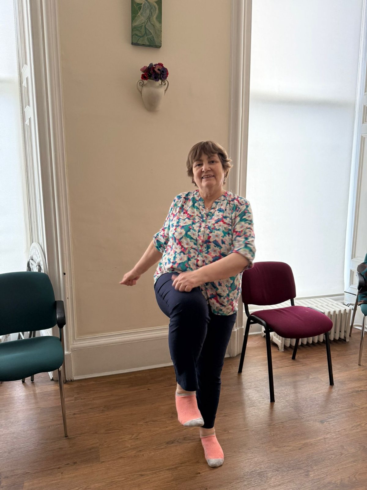 Helen Mc Crarren demonstrating a balance practice in a bright, high-windowed room